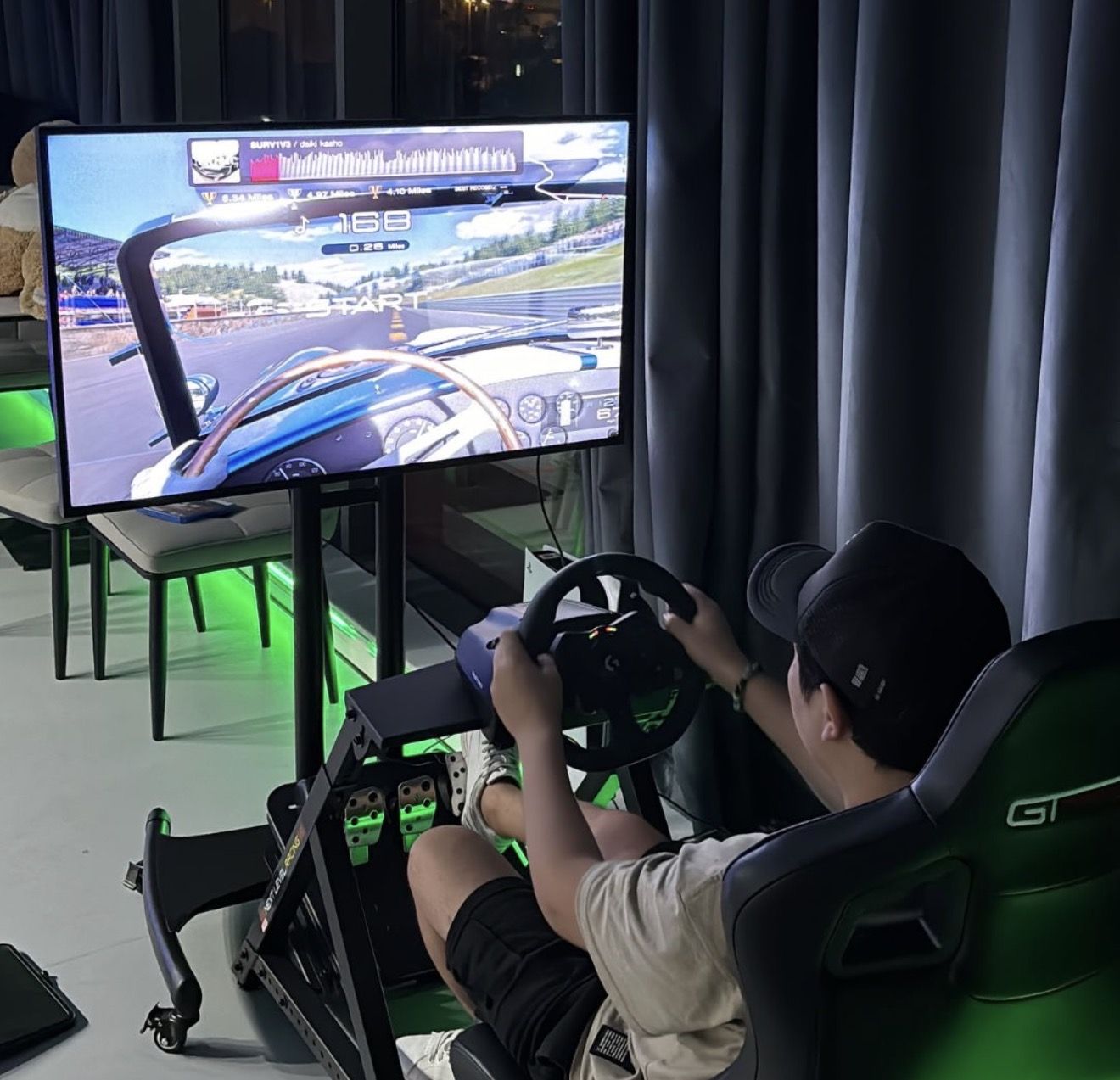 Guest driving the racing simulator with wheel and pedals